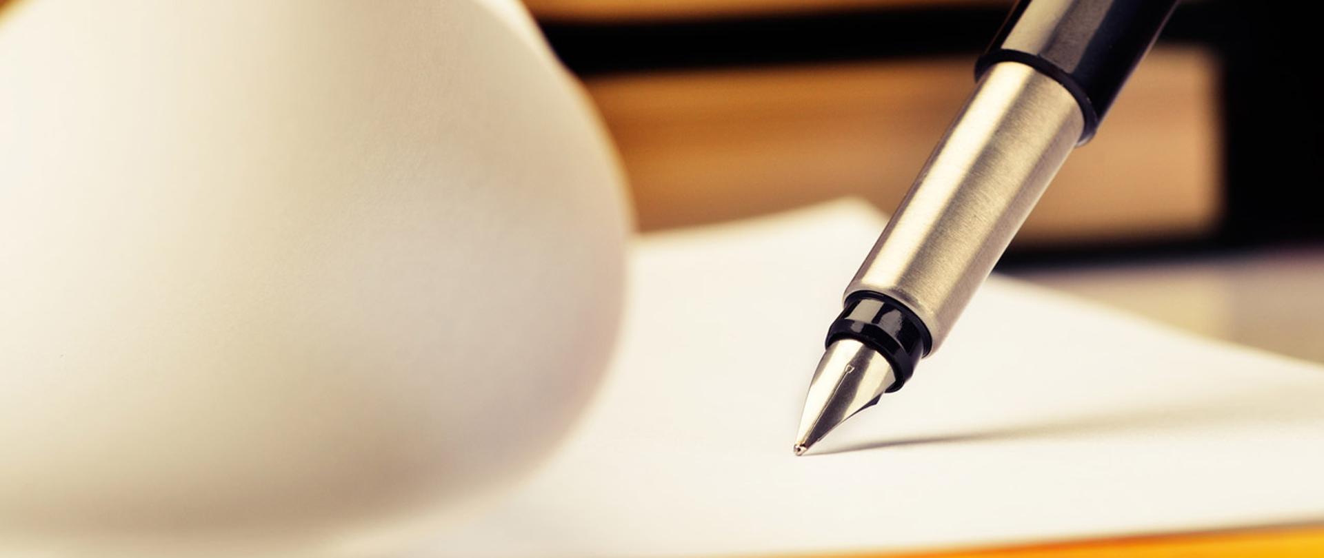 Pióro dotyka kartkę papieru