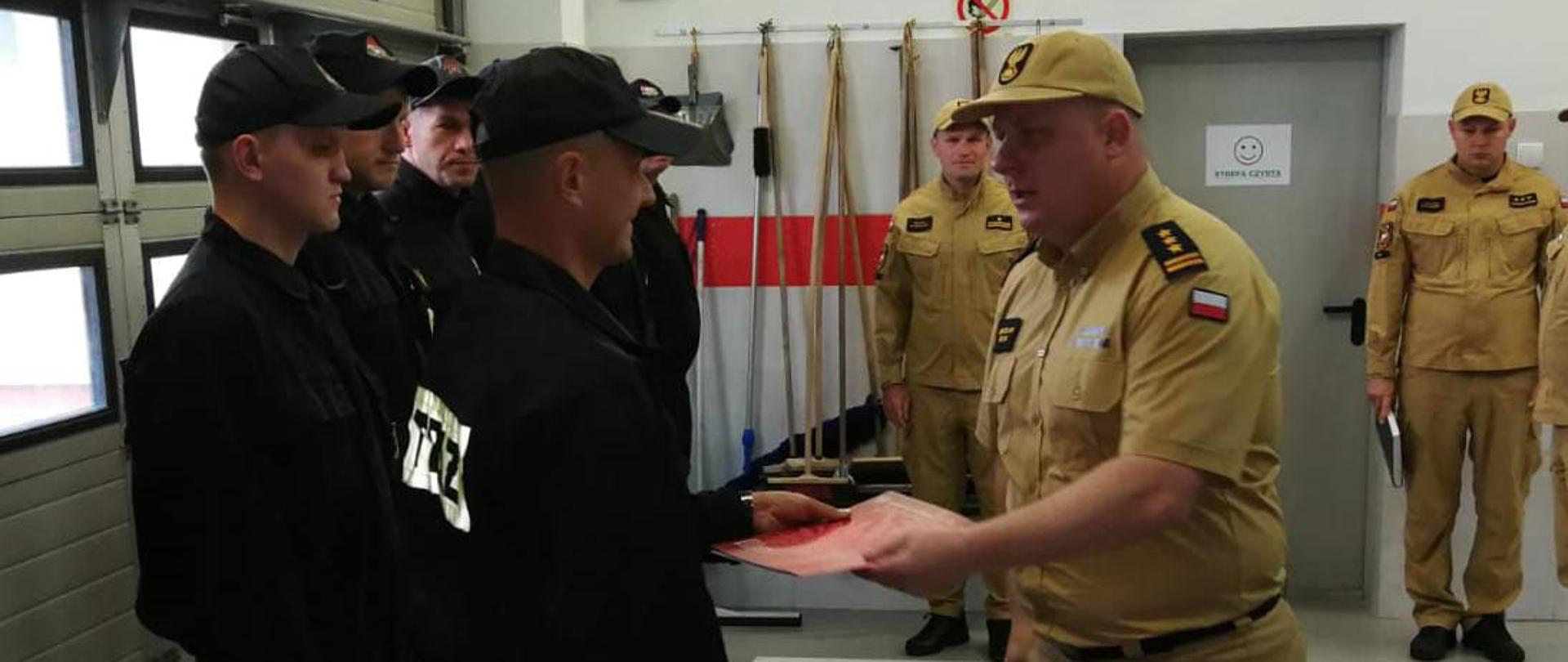 Komendant Powiatowy PSP w Pile wręcza nagrodę strażakowi.