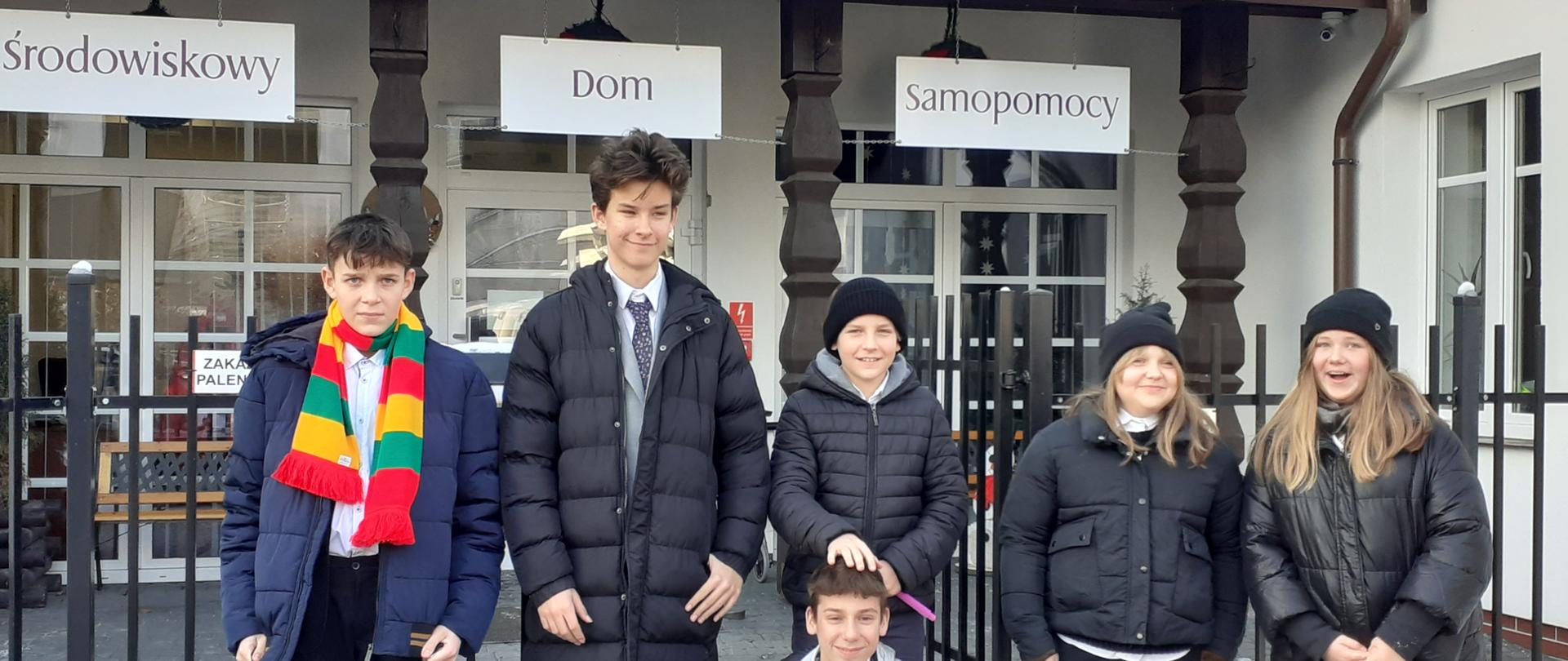 Na tle budynku uczniowie OSM I st. w Piszu.