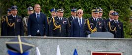 Do mikrofonu przemawia Rektor-Komendant Akademii Pożarniczej nadbryg. Tomasz Klimczak. Za nim goście uroczystości. Wśród nich Komendant Miejski PSP m. st. Warszawy st. bryg. Paweł Adamczyk, Mazowiecki Komendant Wojewódzki PSP nadbryg. Artur Gonera oraz Zastępca Komendanta Głównego PSP nadbryg. Paweł Frysztak. 
