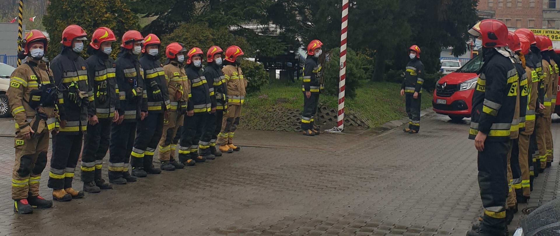 Strażacy podczas uroczystej zmiany służby i podniesienia flagi państwowej na maszt.