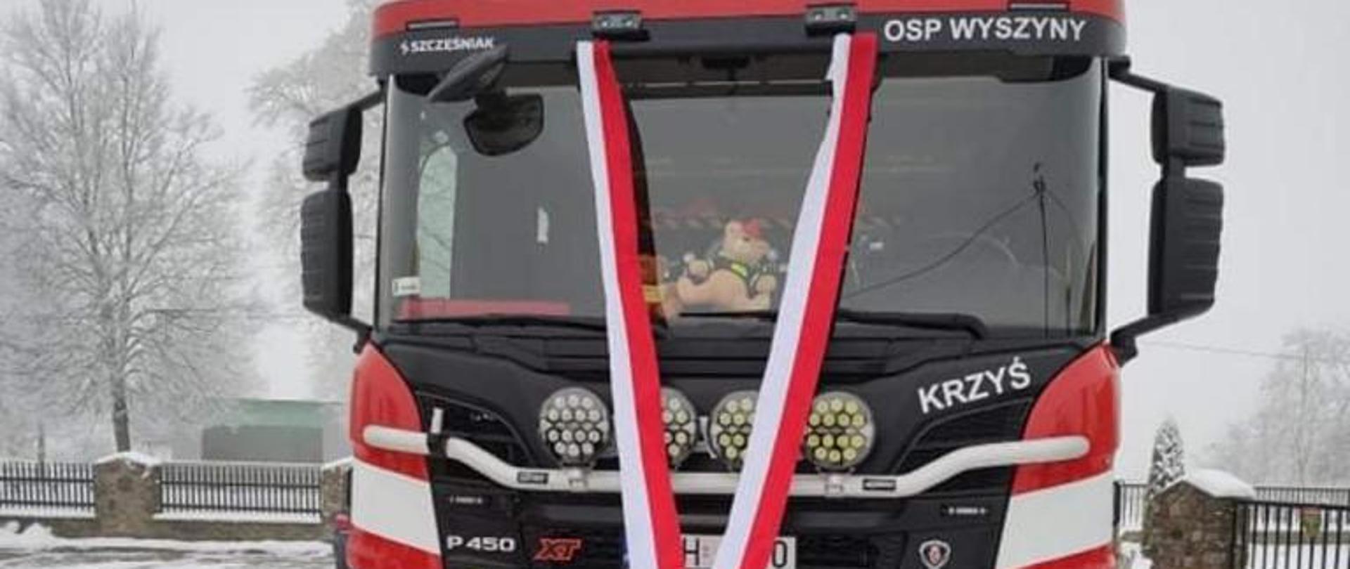 Zdjęcie przedstawia nowy samochód strażacki jednostki OSP Wyszyny.
W tle drzewa.
