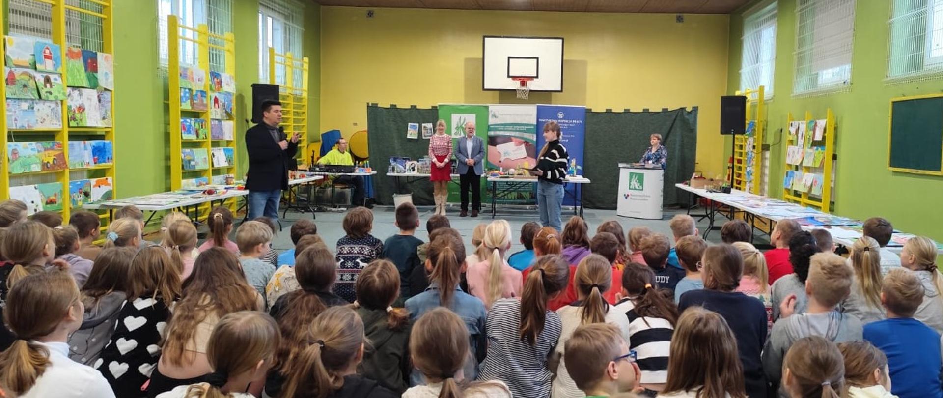 Prelegenci i uczniowie na sali gimnastycznej