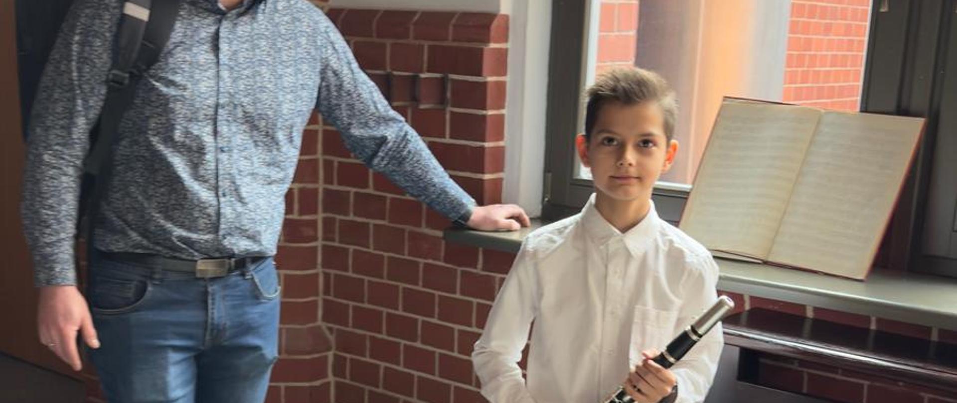 Konrad Pankiewicz z klarnetem i towarzyszącym mu ojcem na czwartych Katowickich Dniach Klarnetu w Katowicach w dniach od szesnastego do osiemnastego marca dwa tysiące dwudziestego piątego roku.