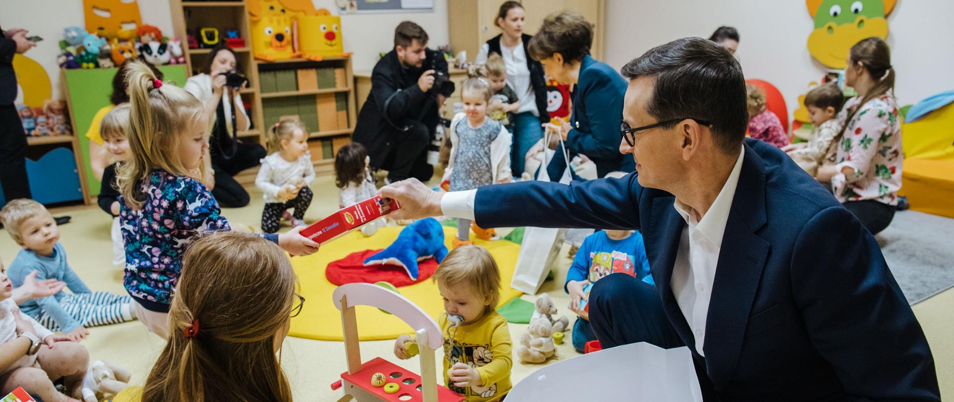 Premier wręcza dzieciom prezenty.