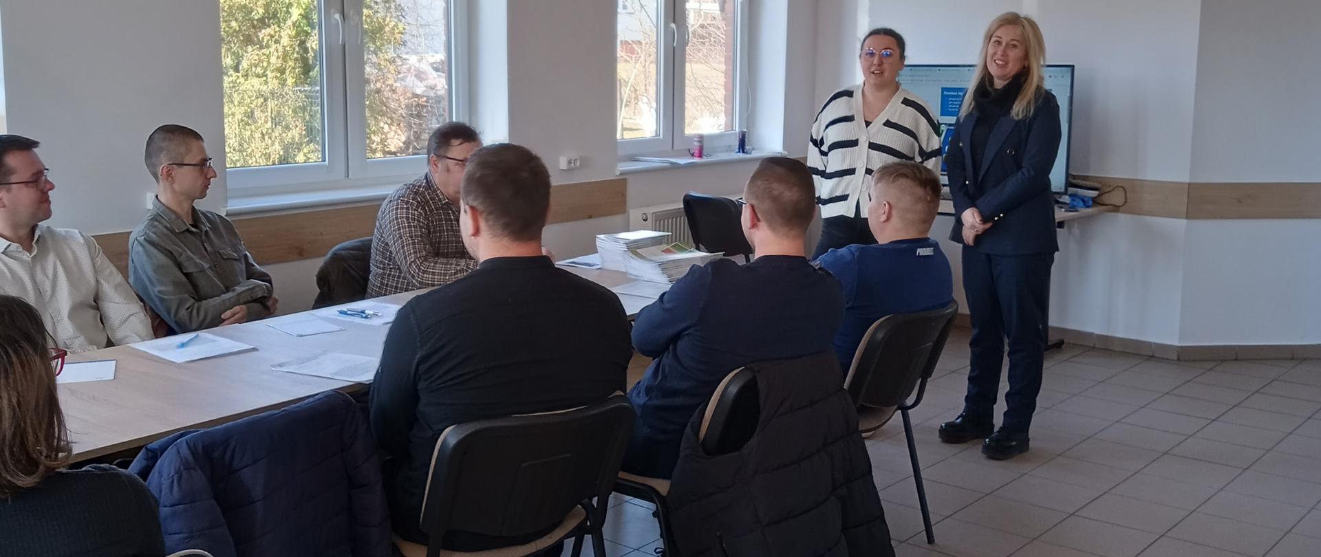 grupa uczestników wysłuchuje prelegenta