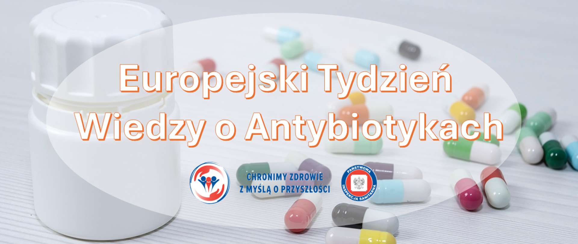 Rozsypane kolorowe kapsułki i biała butelka na jasnym tle. Na środku napis ‘Europejski Tydzień Wiedzy o Antybiotykach’, pod nim dwa logotypy Państwowej Inspekcji Sanitarnej wraz z hasłem: "Chronimy zdrowie z myślą o przyszłości