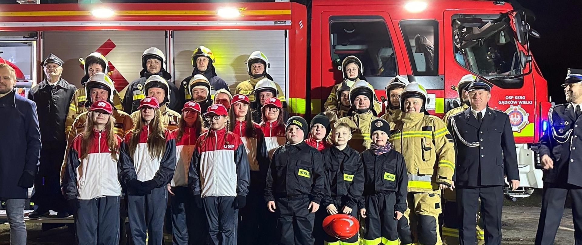 Zdjęcie grupowe druhów OSP na tle nowego wozu
