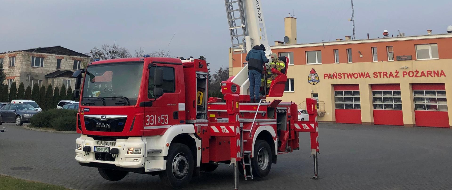 Na zdjęciu nowy samochód z podnośnikiem hydraulicznym na podwoziu MAN TGM 15.290 BB 4x2 zaparkowany na placu KP PSP Pruszcz Gdański.