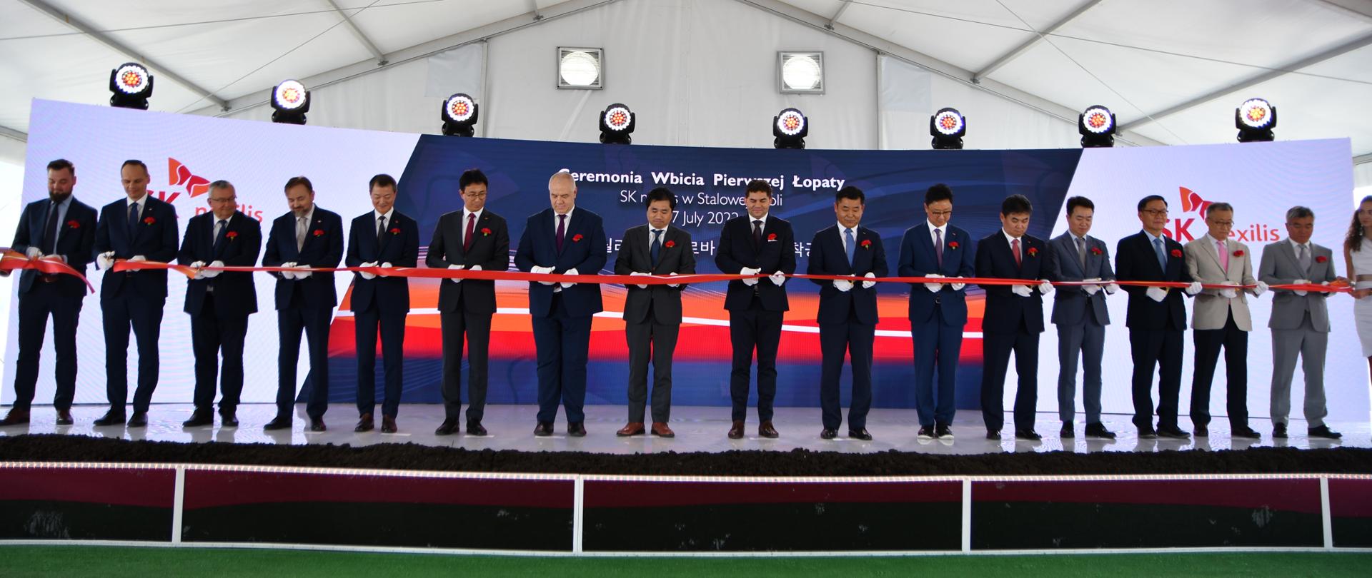 Wicepremier Jacek Sasin i inni uczestnicy przecinają wstęgę. 