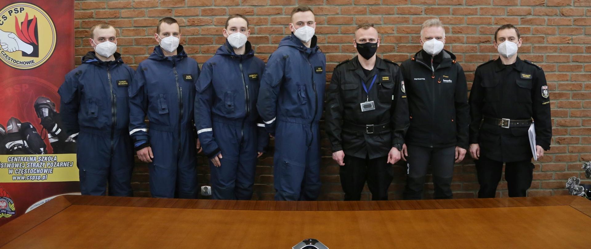 Grupowe zdjęcie uczestników szkolenia w towarzystwie Zastępcy Komendanta Centralnej Szkoły PSP, instruktora ratownictwa wysokościowego KSRG oraz zastępcy Naczelnika Wydziału Szkoleń Specjalistycznych i Współpracy Międzynarodowej