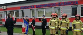 Na zdjęciu poczet sztandarowy Komendy Powiatowej Państwowej Straży Pożarnej w Złotowie, Strażacy z JRG w Złotowie oraz nowo ślubujący strażak. W tle zdjęcia budynek JRG.