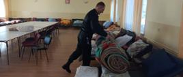 Strażak w remizie OSP przygotowuje miejsca noclegowe dla uchodźców