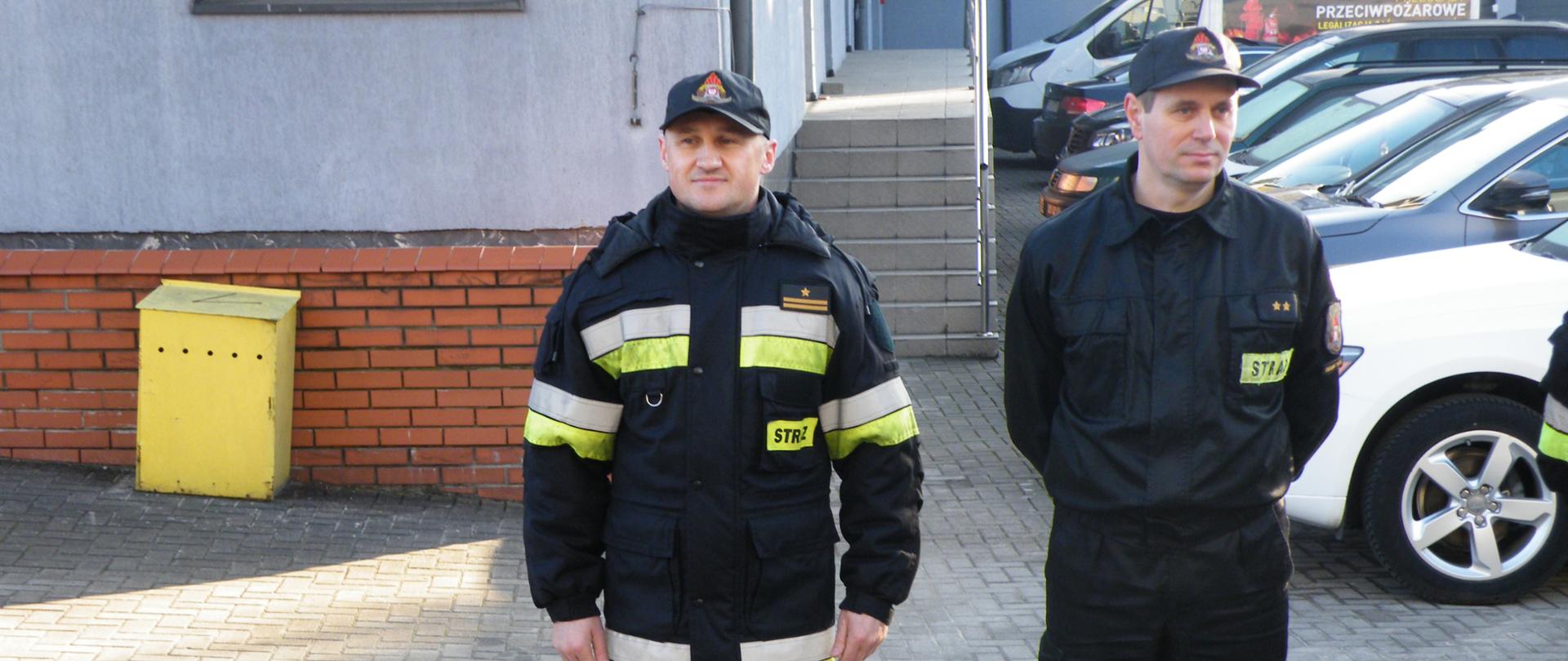 Na zdjęciu widoczni są dwaj strażacy przechodzący na emeryturę