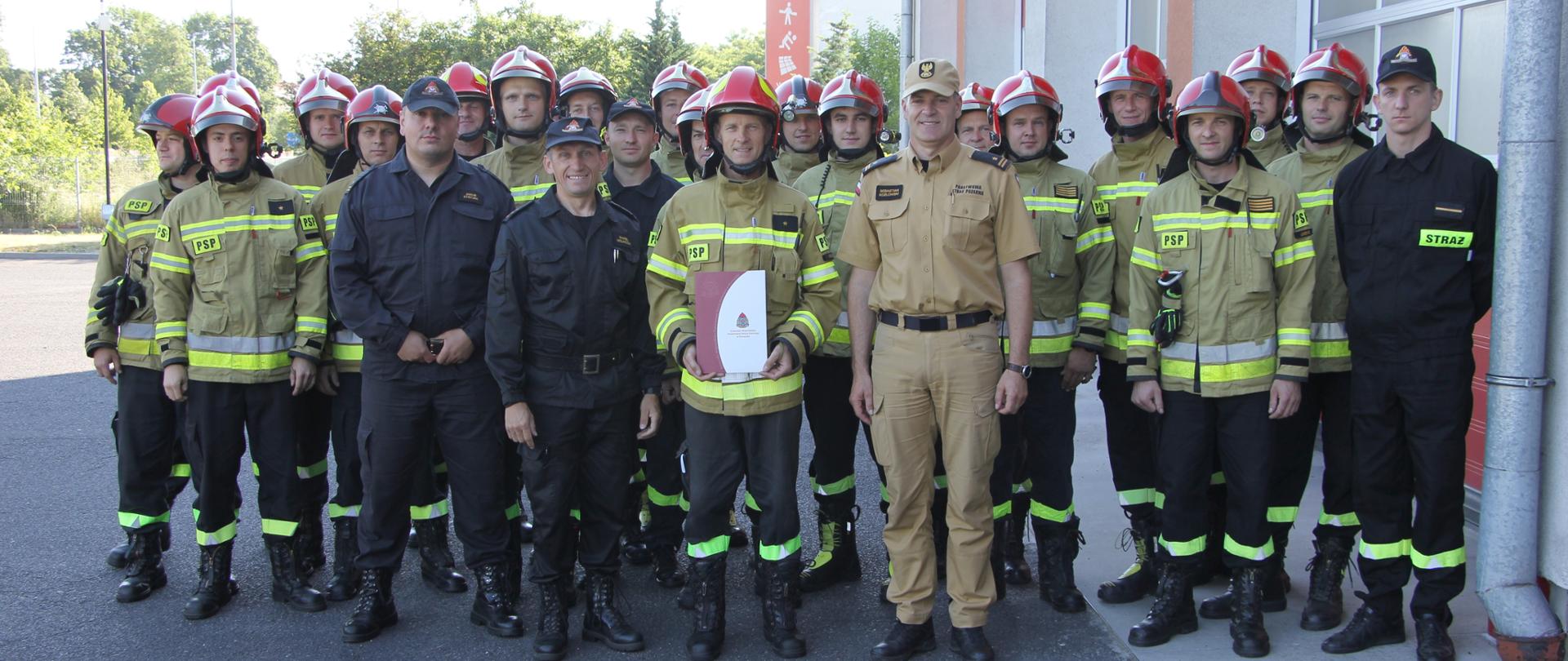 Strażacy stoją w szeregu.