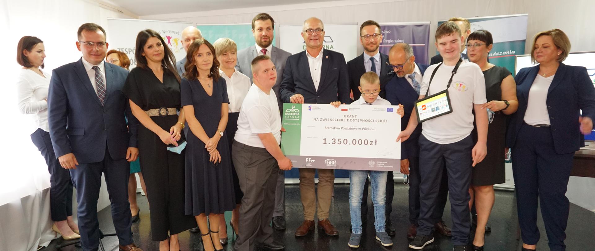 Grupa osób wśród nich minister Buda trzymają czek na kwotę 1,35 mln zł 