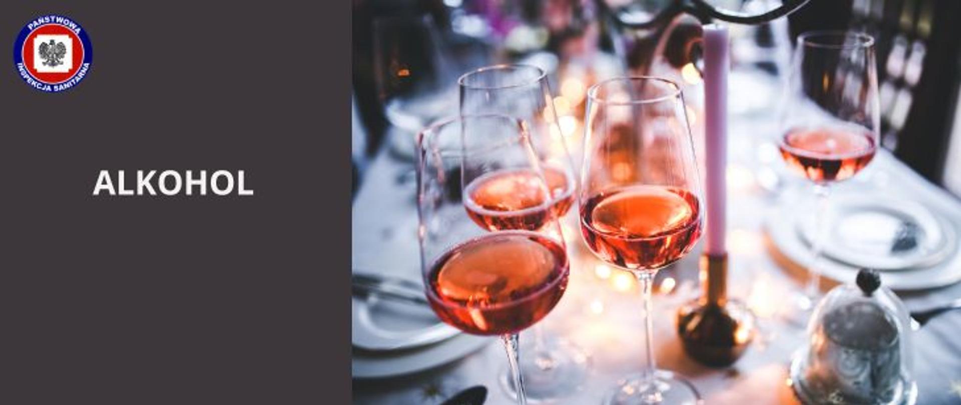 Na zastawionym na biało świątecznym stole stoją cztery kieliszki z różowym winem, po lewej na ciemnobrązowym tle jasny napis Alkohol a w lewym górnym rogi logo Państwowej Inspekcji Sanitarnej.