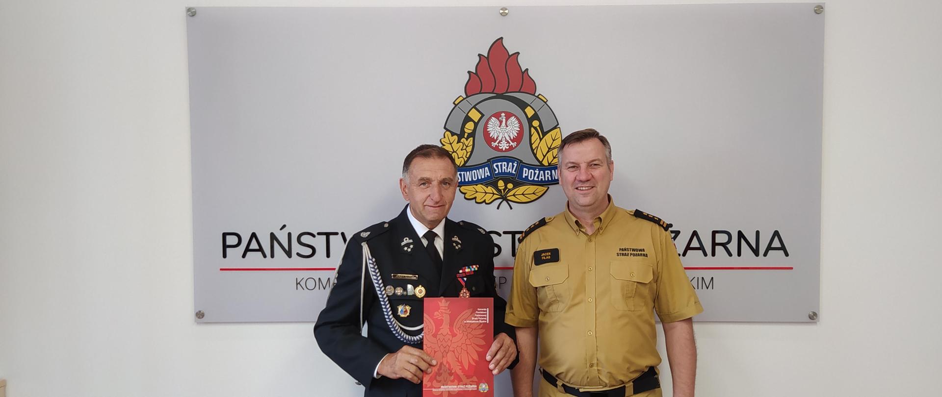 Druh Jerzy Glenc oraz Komendant Powiatowy wspólnie pozują do zdjęcia wraz z wręczoną decyzją o przyznanym świadczeniu emerytalnym