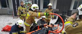 Zdjęcie przedstawia strażaków podczas ćwiczeń, którzy zajmują się osobą poszkodowaną. 