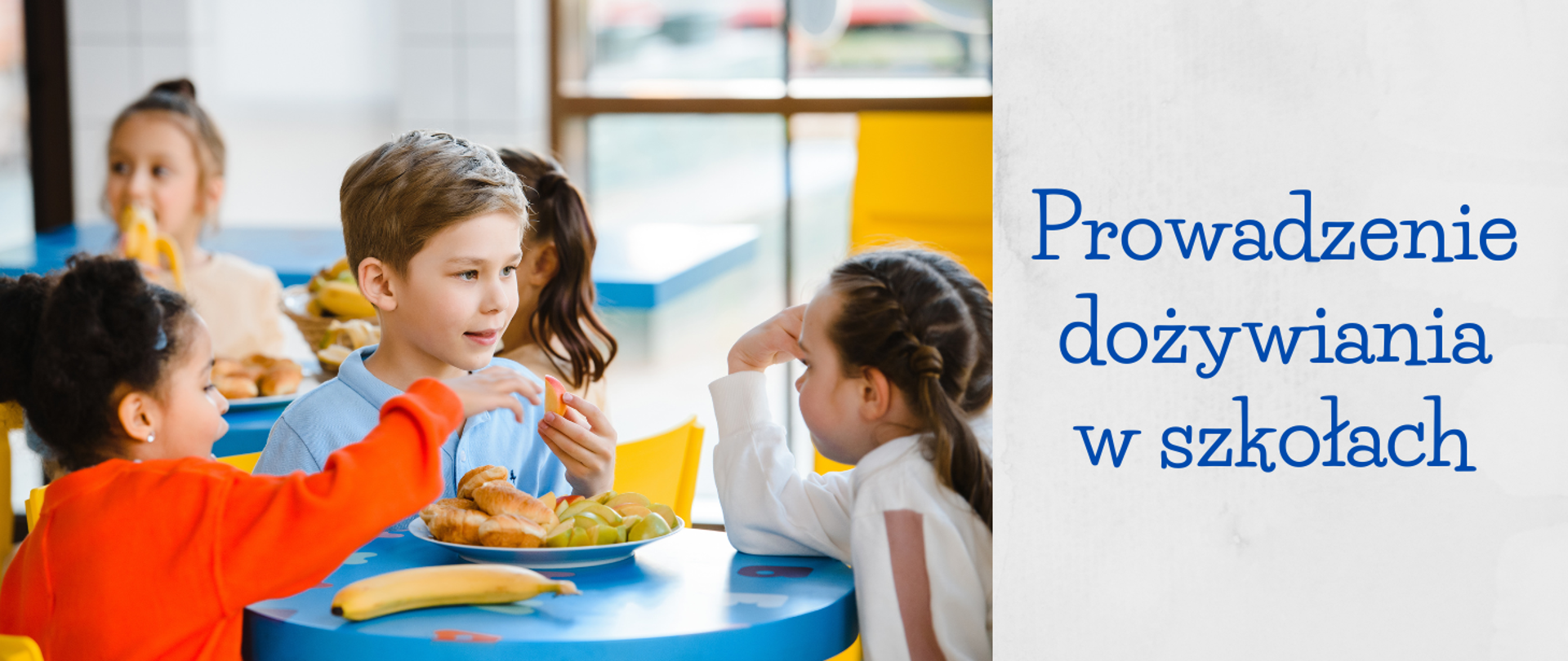 Grafika przedstawia troje dzieci siedzących przy stoliku i jedzących owoce i rogaliki. Po prawej stronie widnieje napis: „Prowadzenie dożywiania w szkołach”.