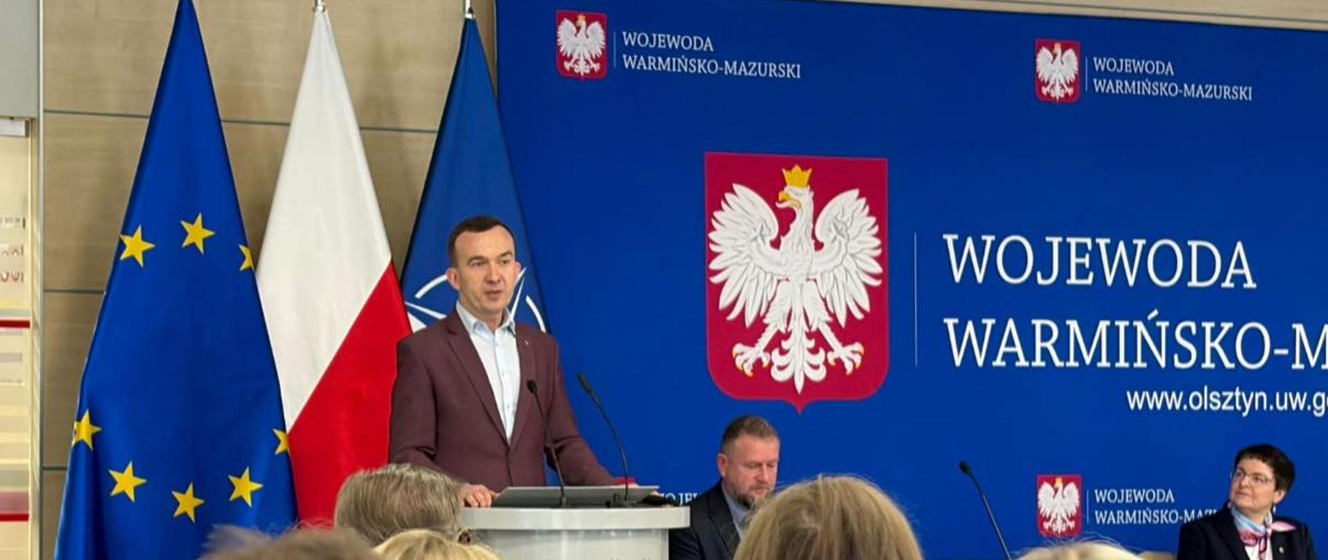 Wicewojewoda Mateusz Szauer przemawia podczas spotkania. Na sali zaproszeni goście.