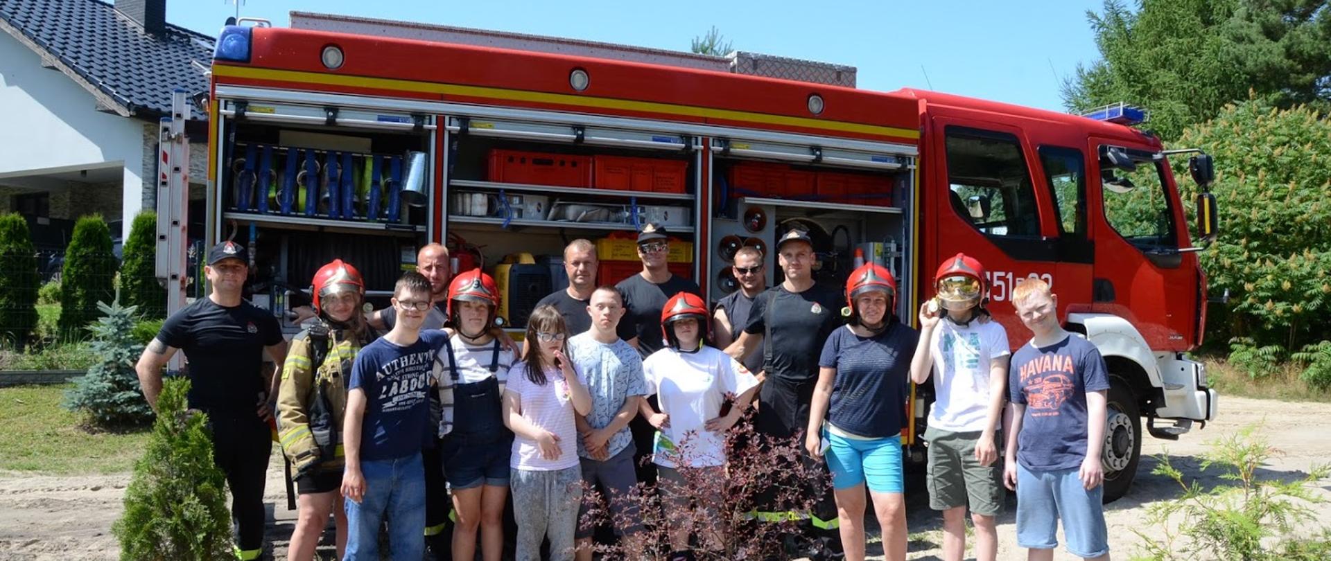 Zdjęcie grupowe na tle wozu gaśniczego