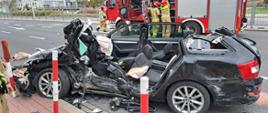 Widoczny wrak czarnego samochodu osobowego bez dachu.
Samochód osobowy marki Skoda, po działaniach strażaków, którzy uwolnili kierowcę z wraku pojazdu po wypadku.