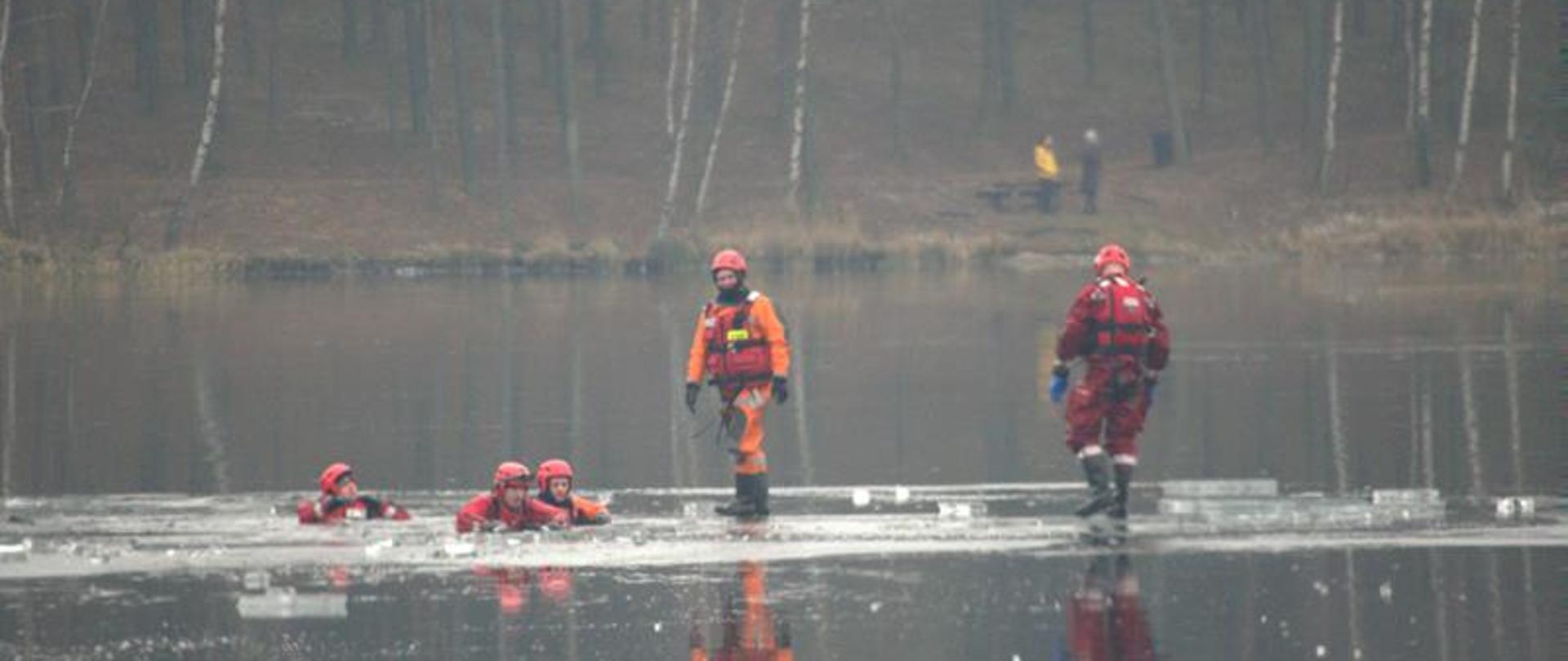 Strażacy w ubraniach do ratownictwa wodno-lodowego w trakcie zajęć praktycznych.