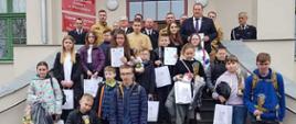Zdjęcie przedstawia uczestników turnieju OTWP oraz strażaków, którzy stoją na schodach przed budynkiem 
