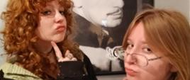 Na zdjęciu Antonina i Oliwia widziane z półprofilu, podpierają brody palcami wskazującymi i robią bardzo "mądre" miny. W tle czarnobiałe zdjęcie - portret Salvadora Dali w młodości