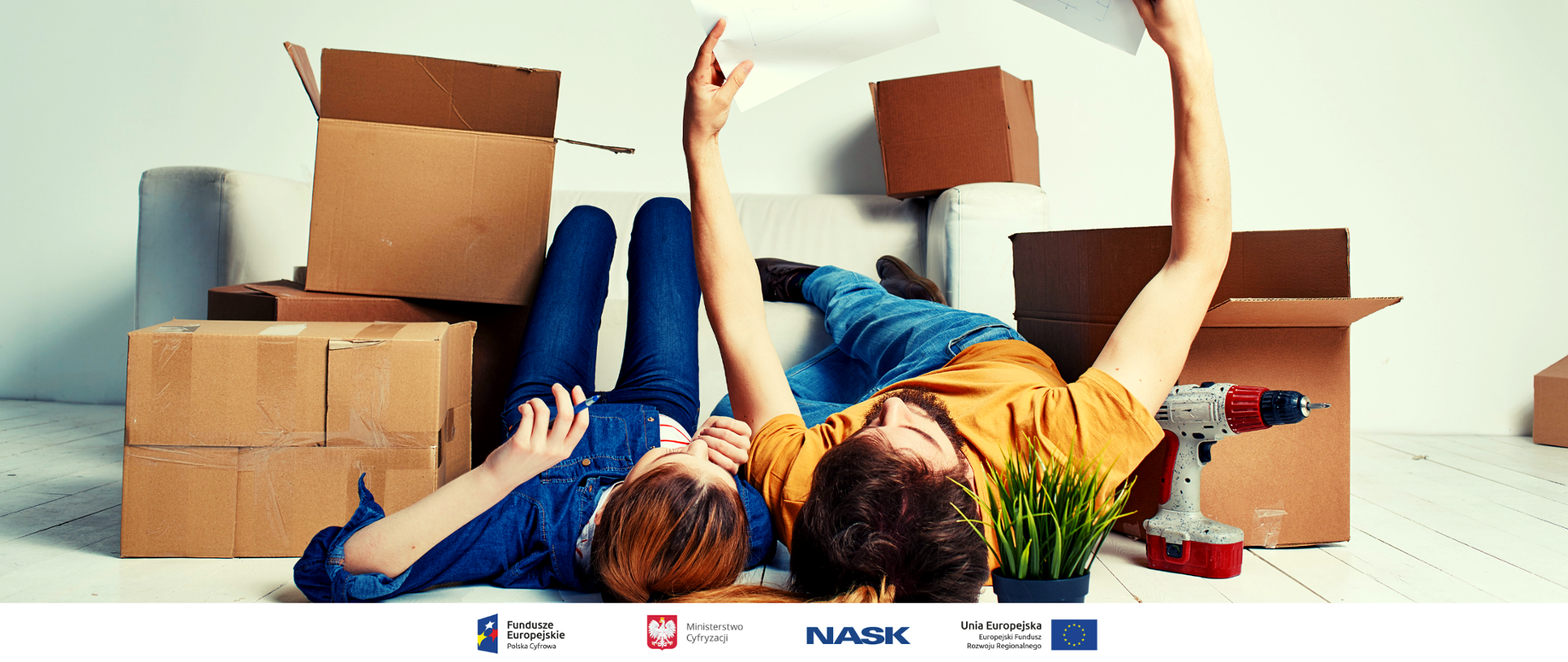 Dwoje młodych ludzi leży na podłodze. Dookoła kartony