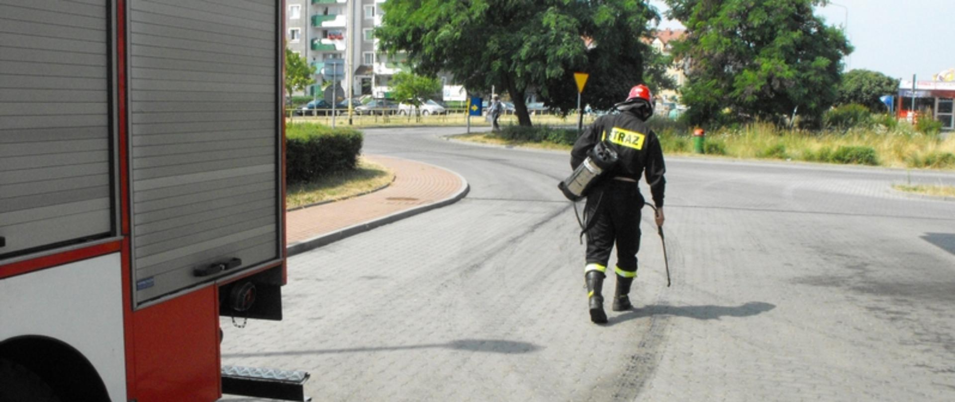 Zdjęcie przedstawia strażaka neutralizującego substancję olejową