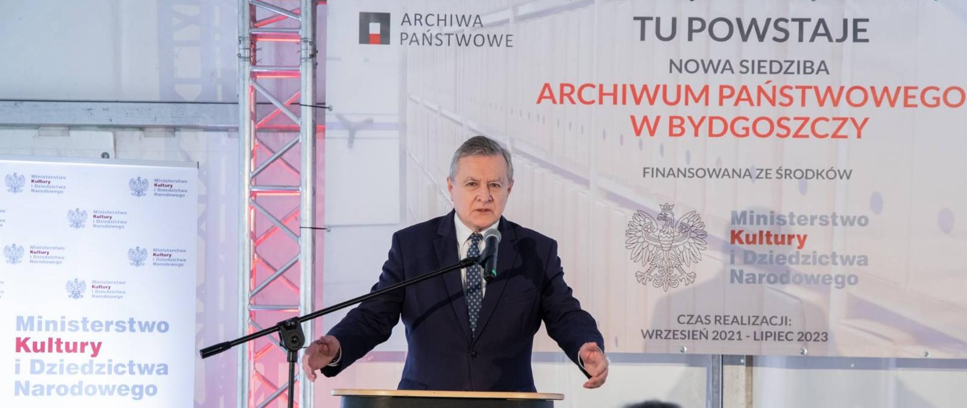 Jeden mężczyzna stojący przy mównicy i wypowiadający się 