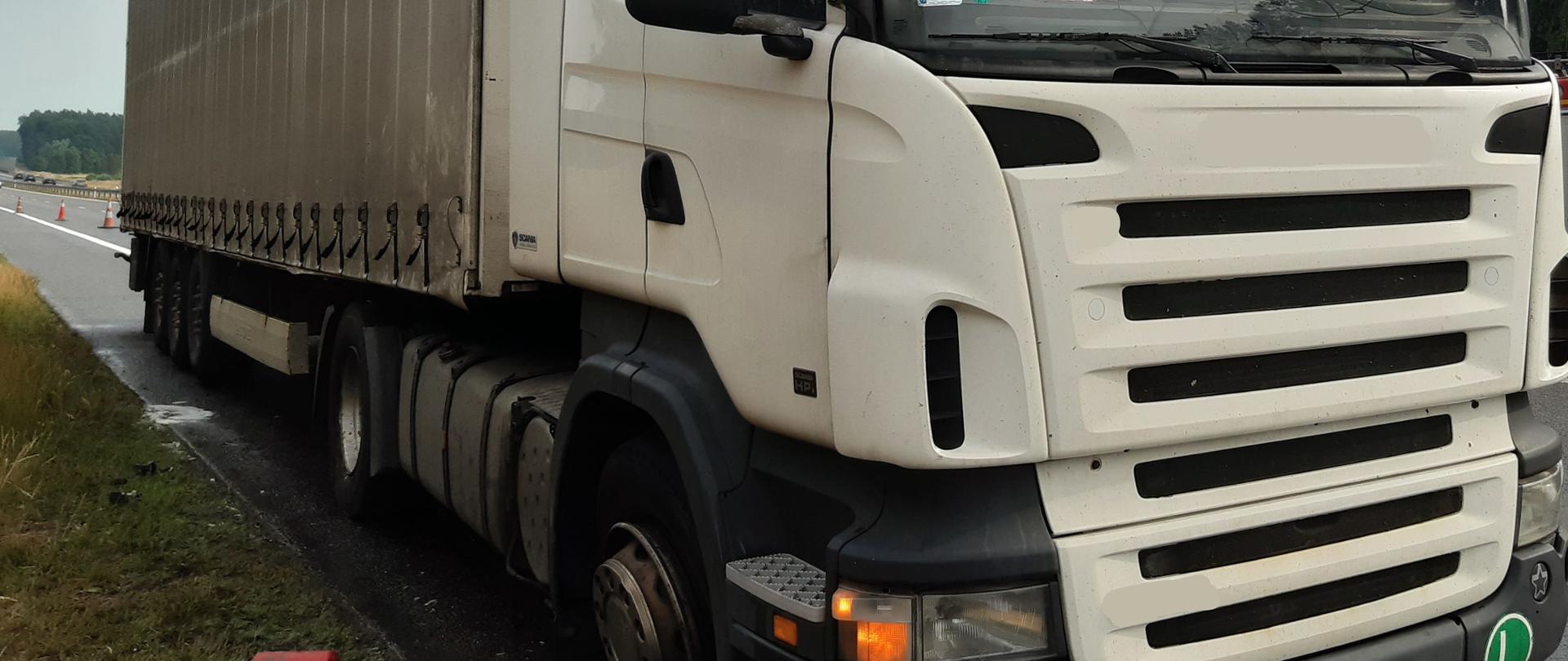 Na zdjęciu samochód ciężarowy i gaśnice leżące na poboczu drogi