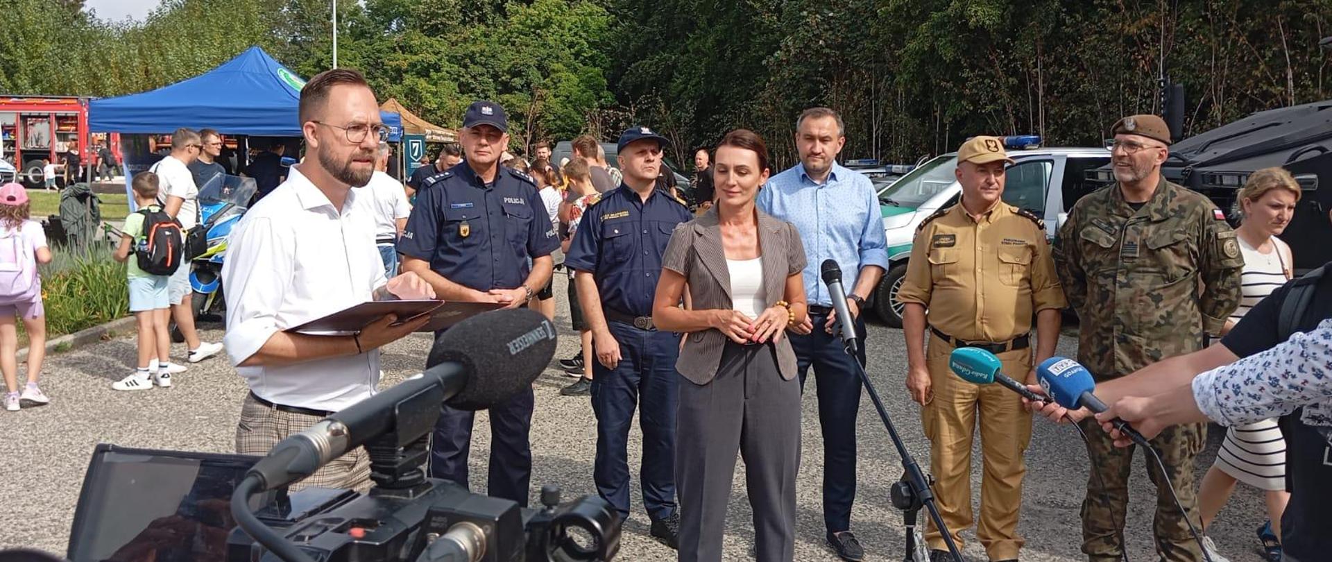 Na konferencji prasowej stoją: Beata Rutkiewicz - Wojewoda Pomorska, Tomasz Augustyniak-wiceprezydent Gdyni, komendant wojewódzki Policji w Gdańsku insp. Bogusław Ziemba, dowódca 7. Pomorskiej Brygady Obrony Terytorialnej kmdr Tomasz Laskowski, pomorski komendant wojewódzki PSP w Gdańsku st. bryg. Jacek Niewęgłowski oraz komendant Morskiego Oddziału Straży Granicznej kontradm. SG Andrzej Prokopski. 