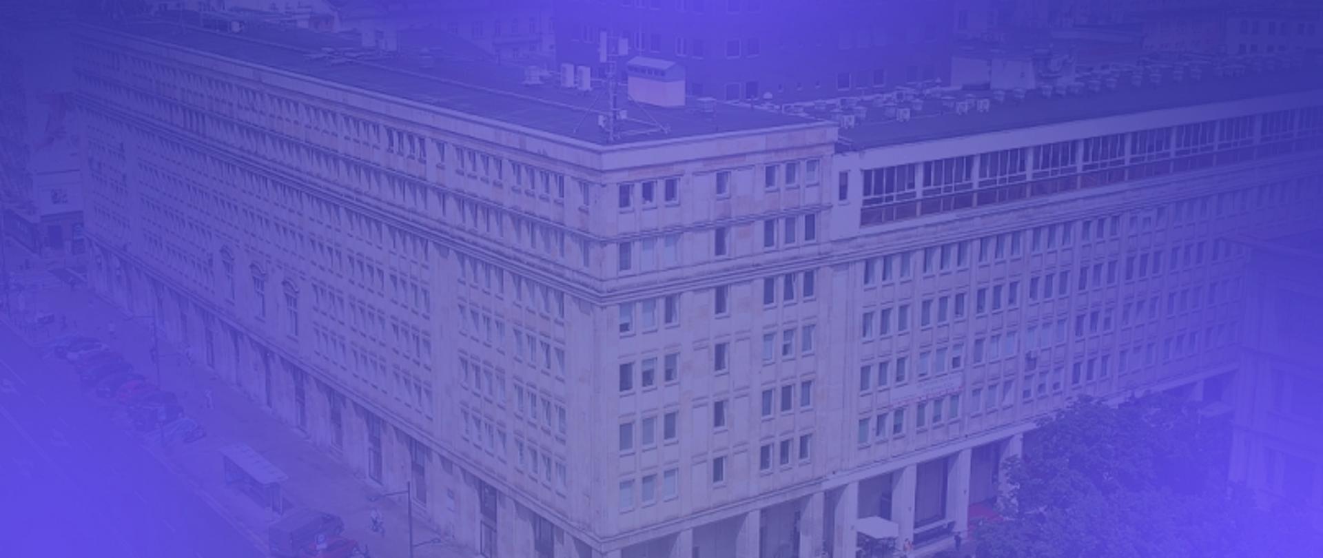 Budynek z wieloma oknami, ulica z samochodami i drzewami, zdjęcie z niebiesko-fioletowym efektem.