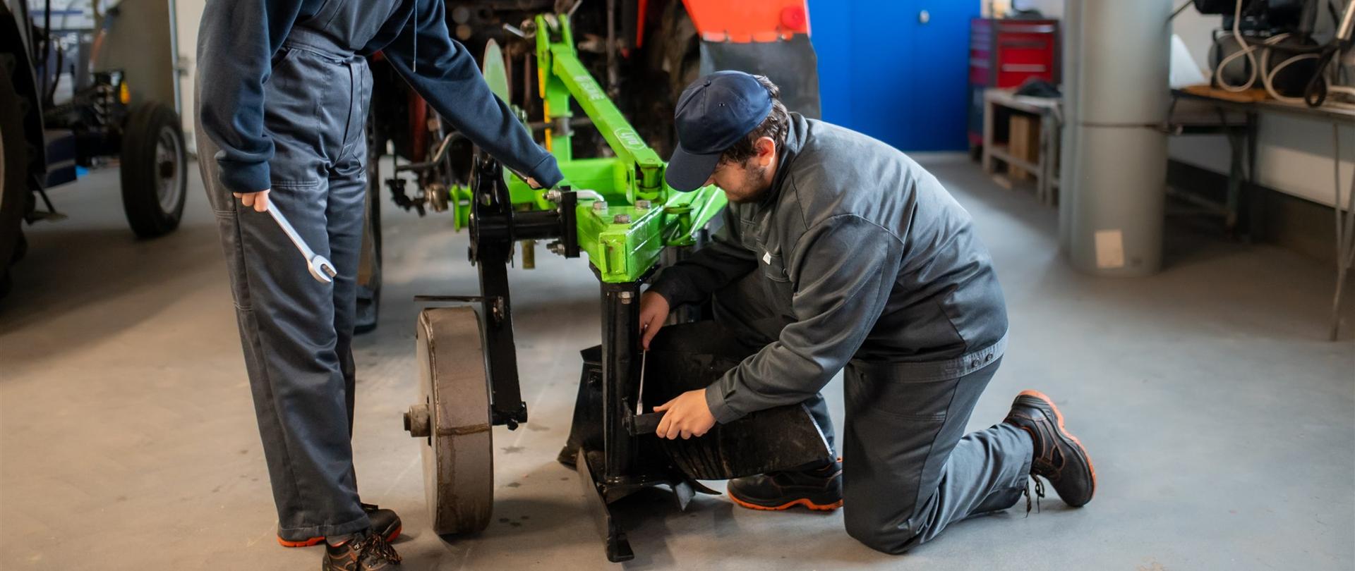 Uczniowie reperujący pług rolniczy