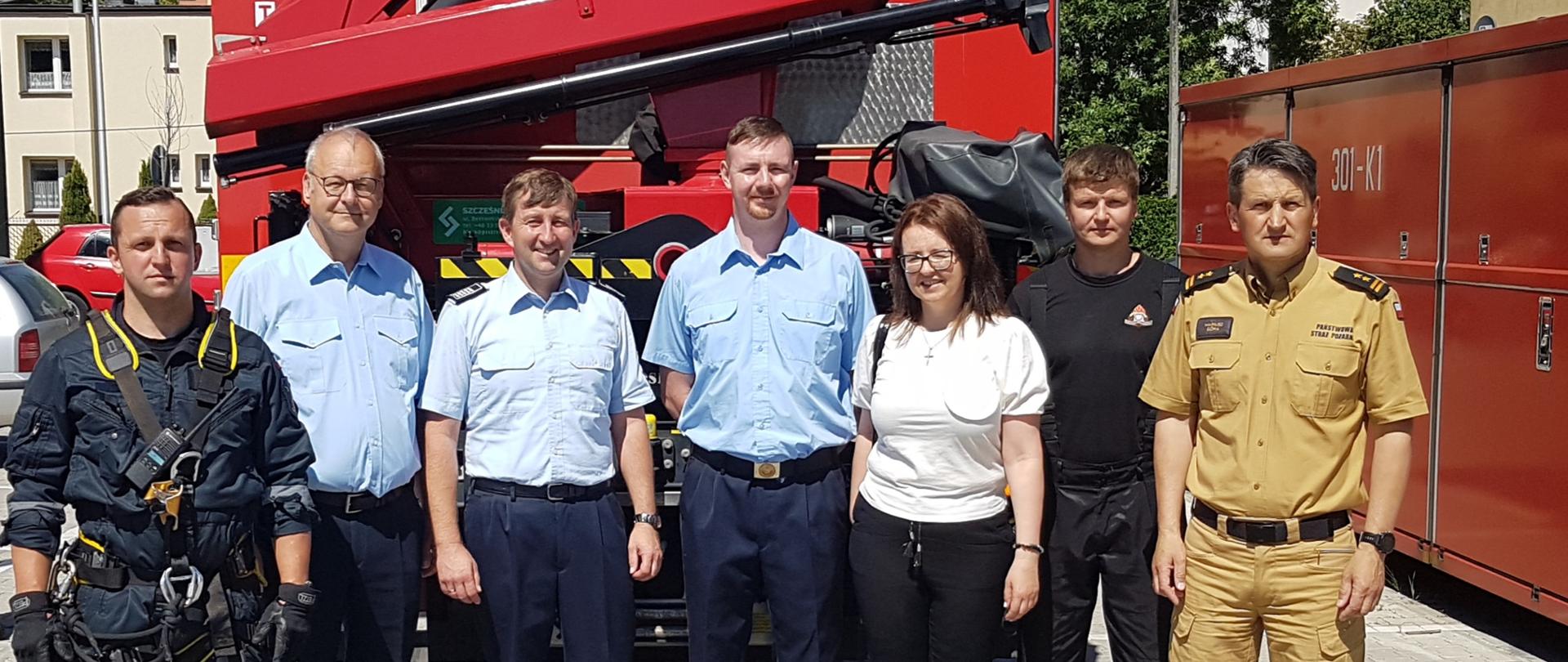 Wizyta strażaków z miasta partnerskiego Gotha u kieleckich strażaków - zdjęcie przedstawia gości z Niemiec i strażaków z Kielc na tle samochodu ratownictwa technicznego w JRG 3 Kielce.