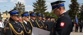 Zastępca Komendanta Wojewódzkiego wręcza strażakom awanse na wyższe stopnie służbowe.
