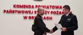 Na zdjęciu Komendant Powiatowy wręcza akt mianowania na wyższe stanowisko służbowe