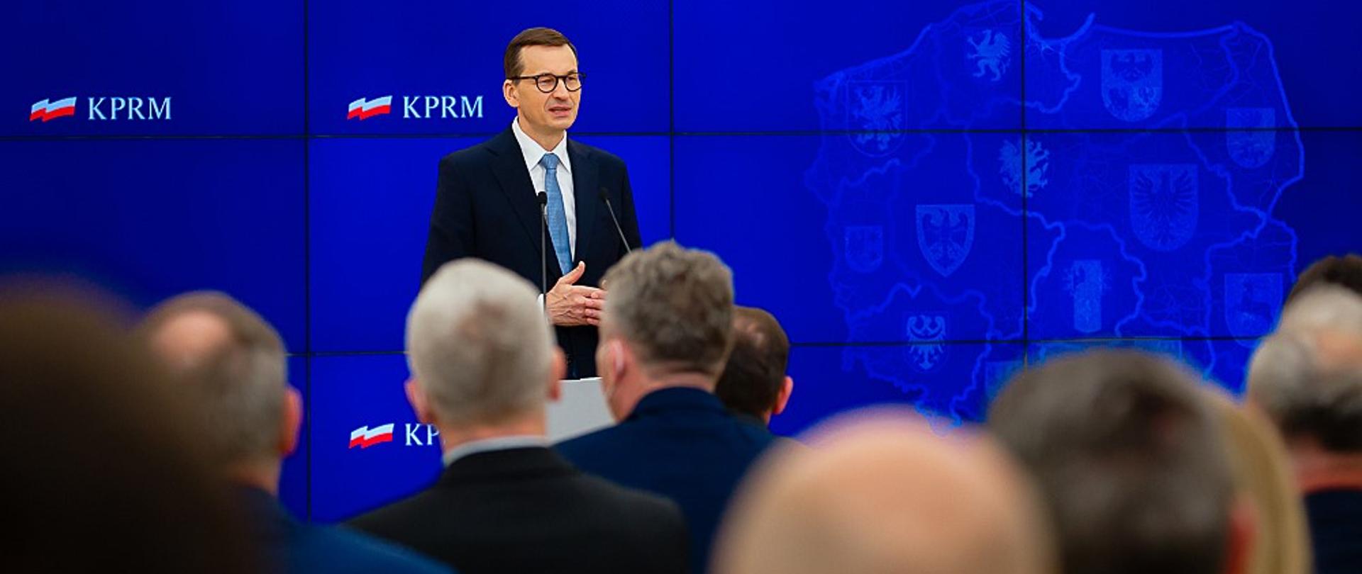 Premier Mateusz Morawiecki przemawia przy mównicy.