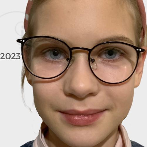 Wizerunek dziewczynki w okularach na białym tle. 