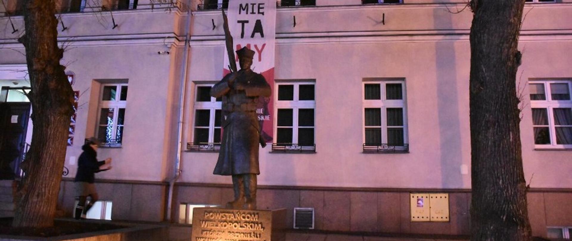 Na zdjęciu widoczny pomnik powstańca wielkopolskiego. W tle budynek urzędu gminy.