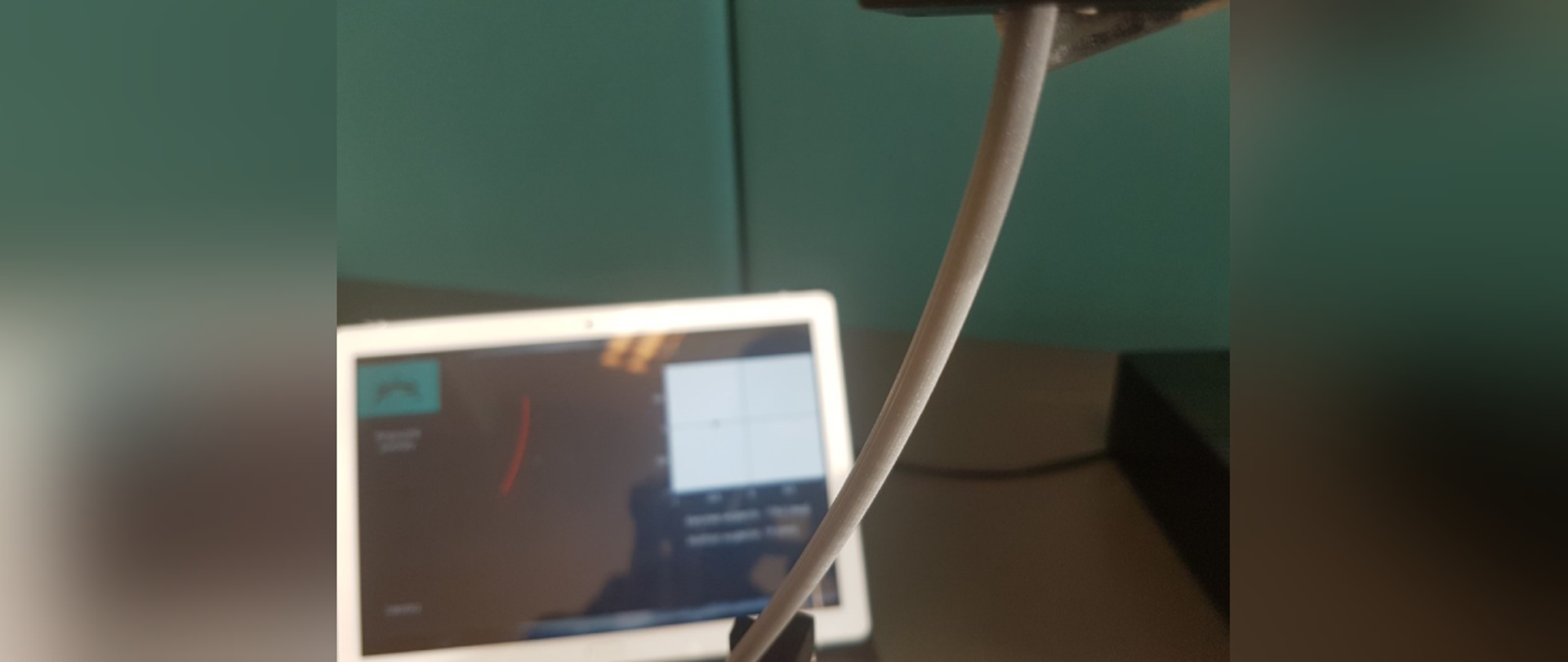 Demonstrator światłowodowego czujnika zgięć umożliwiający precyzyjny pomiar amplitudy i kierunku zgięć w zakresie 0-360st. Na pierwszym planie wygięta głowica pomiarowa ze zintegrowanym światłowodem specjalnym opracowanym w ramach projektu, na drugim planie oprogramowanie, które na podstawie mocy transmitowanej przez światłowód wykreśla kierunek i stopień odkształcenia.