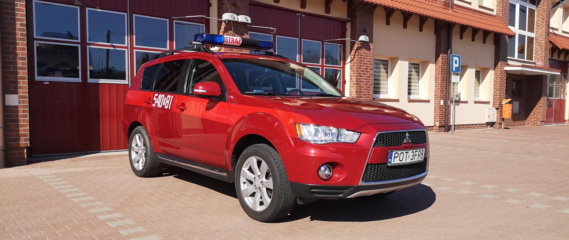 Na zdjęciu samochód specjalny lekki kwatermistrzowski Mitsubishi Outlander na placu manewrowym przed garażami Jednostki Ratowniczo-Gaśniczej
