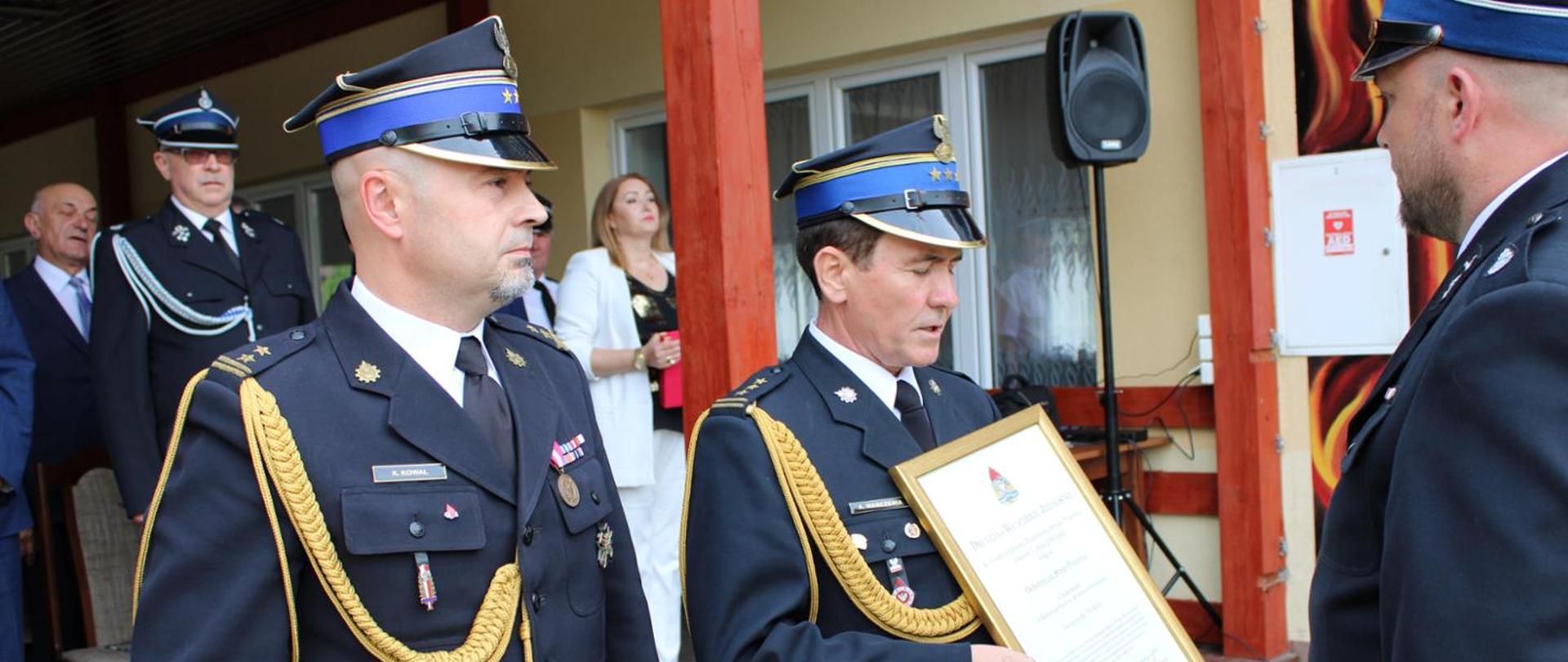 Na zdjęciu widać zastępcę podkarpackiego komendanta wojewódzkiego PSP st. bryg. Andrzeja Marczenię oraz komendanta powiatowego PSP w Jarosławiu bryg. Krzysztofa Kowala, którzy wręczają druhowi OSP Jankowice akt włączenia tejże jednostki do KSRG