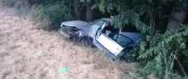 Widoczne miejsce zdarzenia uszkodzony pojazd który wypadł z drogi i znajduje się w przydrożnym rowie.