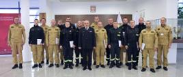 Pamiątkowe zdjęcie grupowe funkcjonariuszy PSP uczestniczących w szkoleniu dla kierowców pojazdów uprzywilejowanych (16 osób) w towarzystwie Komendanta Centralnej Szkoły PSP oraz dwóch oficerów CS PSP