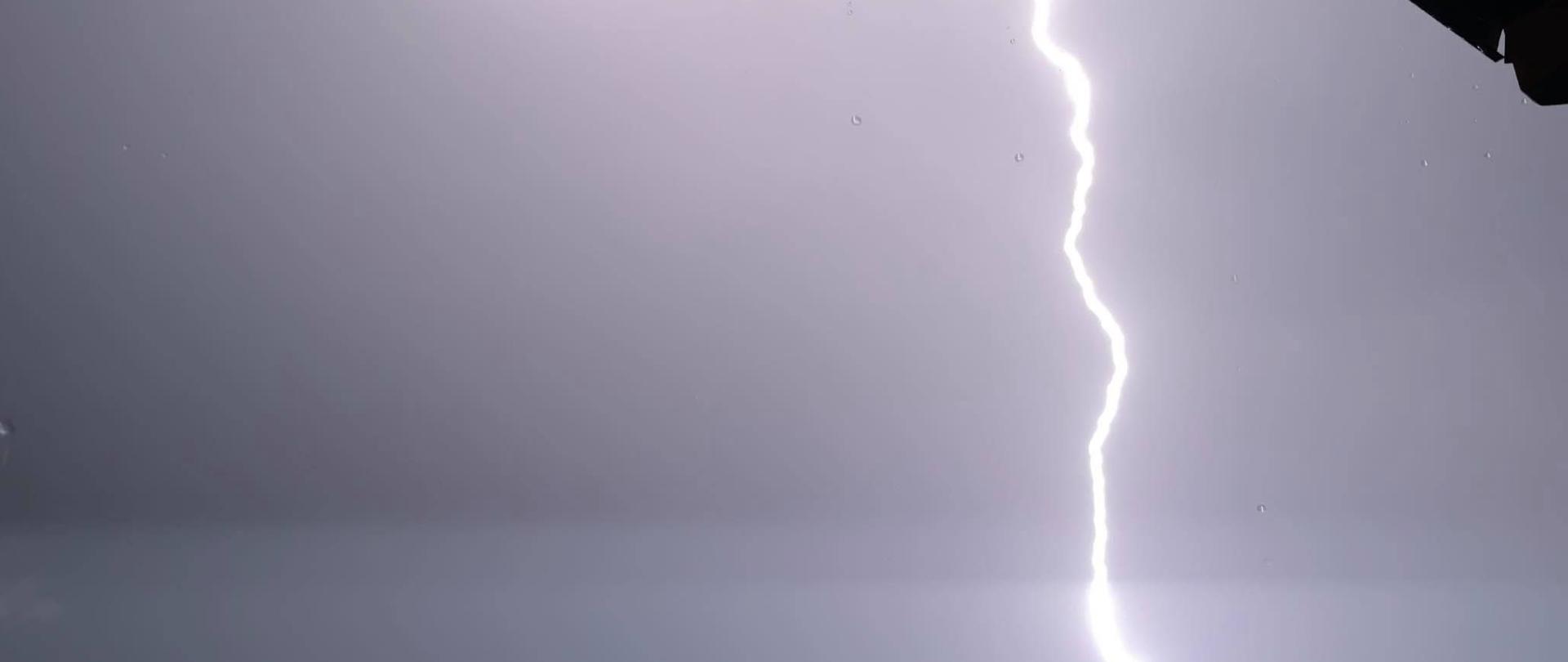 Zdjęcie przedstawia doziemienie piorunu wykonane w porze nocnej