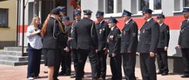 Pamiątkowe ujęcie z przebiegu uroczystego apelu przed budynkiem strażnicy w Żeleźnikach. W tle widoczna jest biało-czerwona flaga oraz pamiątkowa tablica odsłonięta z okazji jubileuszu 100-lecia jednostki (1926–2026). Przedstawiciele PSP i OSP wspólnie uczestniczą w oficjalnej części programu.